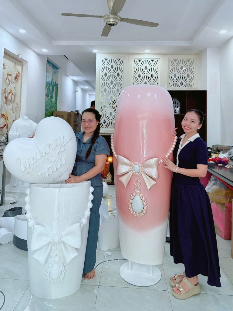 Mô hình Standee Móng Nail 3D khổng lồ đính nơ và ngọc trai đặt trước cửa tiệm Thảo Beauty